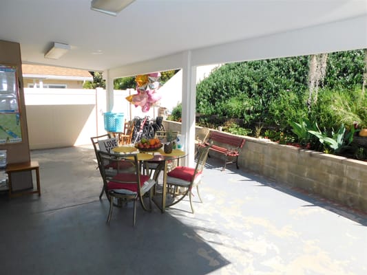 Outdoor patio with a table, chairs, and decorative balloons.