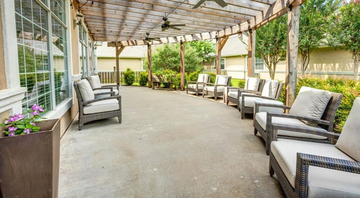 Covered outdoor seating area with chairs and plants