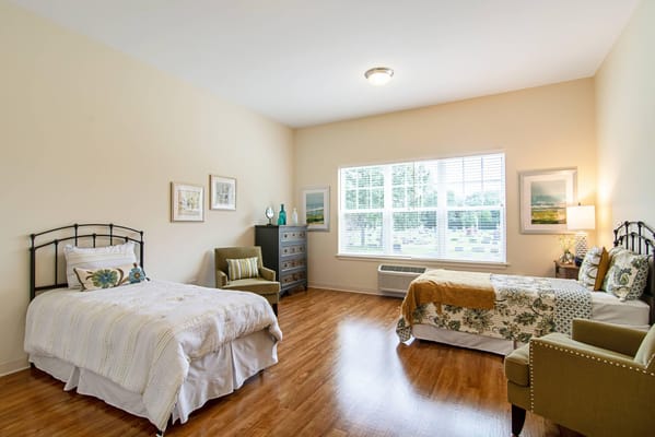Spacious bedroom with two beds and a window view