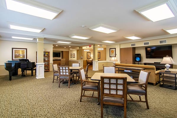 Brightly lit common area with seating and piano