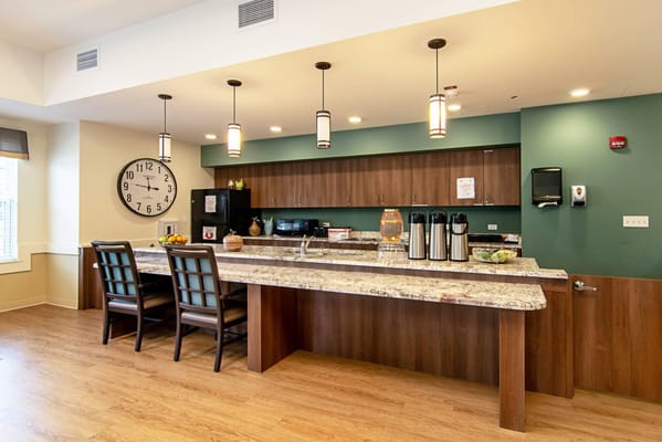 A modern kitchen with a large countertop and seating at Emerald Place.