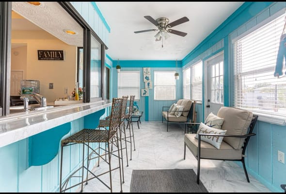 Bright and airy sunroom with seating and bar area