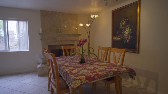 Dining table with floral tablecloth and a painting on the wall