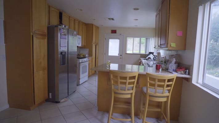 Bright kitchen with wooden cabinets and bar stools
