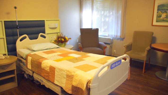 Cozy patient room with a bed and seating area