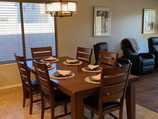 A well-set dining table with plates and napkins in a cozy dining area.