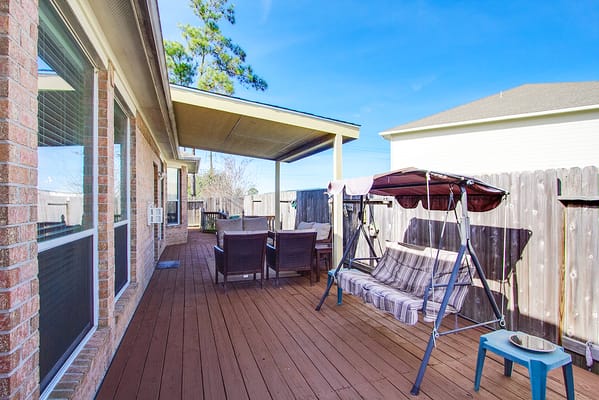 Outdoor patio with seating and swing at Assisted Living Homes