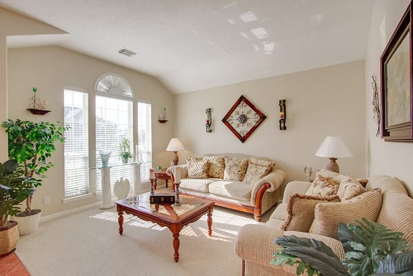 Bright and inviting living room with sofas and large windows.