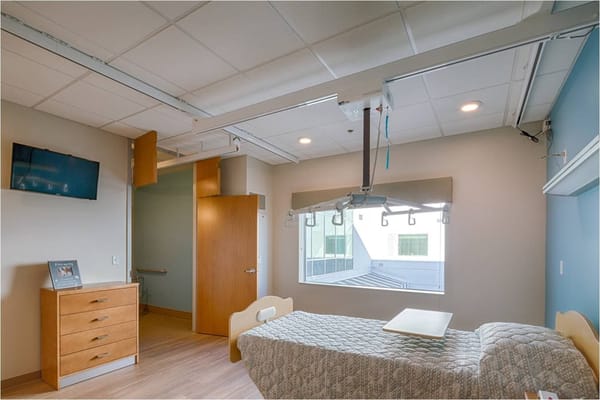 Bright interior of a resident room with hospital bed