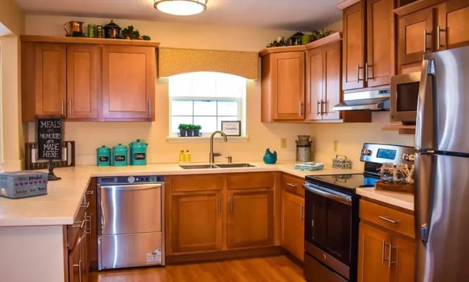 Bright kitchen area with wooden cabinets and appliances