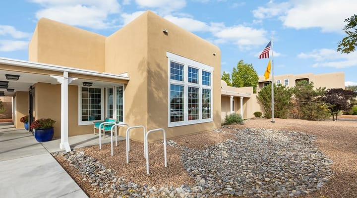 Exterior view of Kingston Residences showing landscaping and flags.