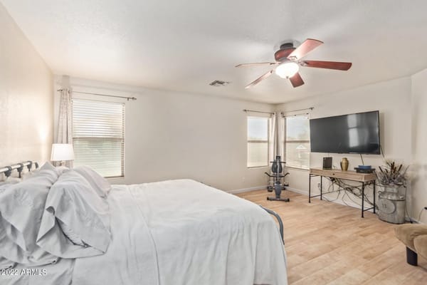 Bright bedroom with a bed, desk, and exercise equipment
