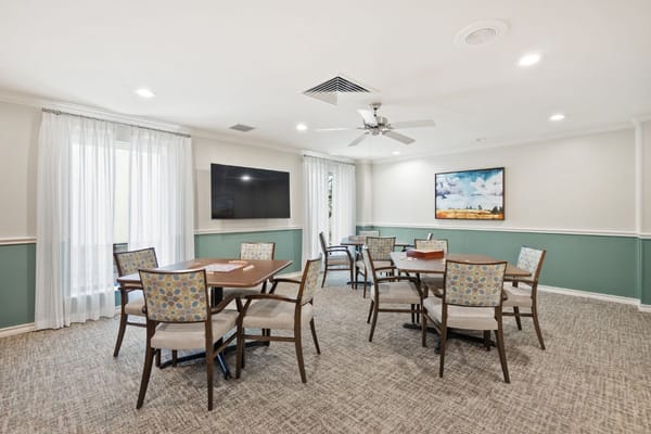 Bright common area with tables and chairs in Meadowstone Place