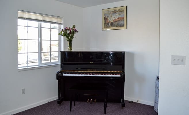 Piano in a well-lit room with a window