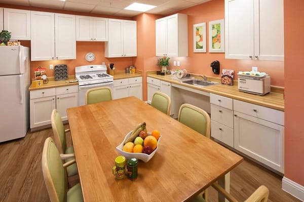 Bright kitchen with a wooden dining table and fresh fruit