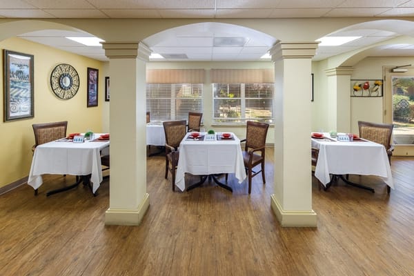 Bright dining room with neatly set tables and chairs