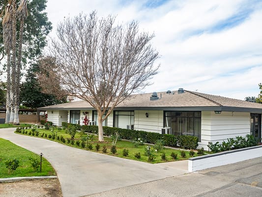 Exterior view of Mission Care Center with gardens.