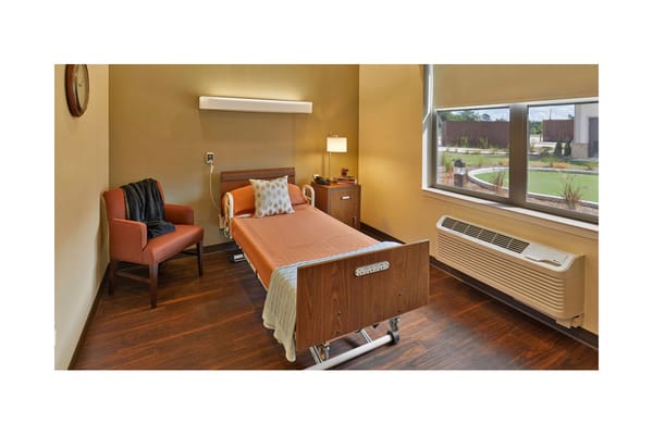 Cozy private resident room with medical bed and chair