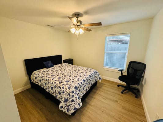 Cozy bedroom with a floral-patterned bedspread and chair