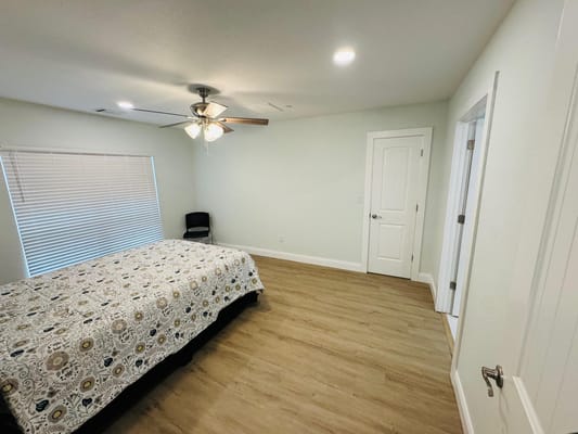 Bright interior of a resident room with a bed and chair