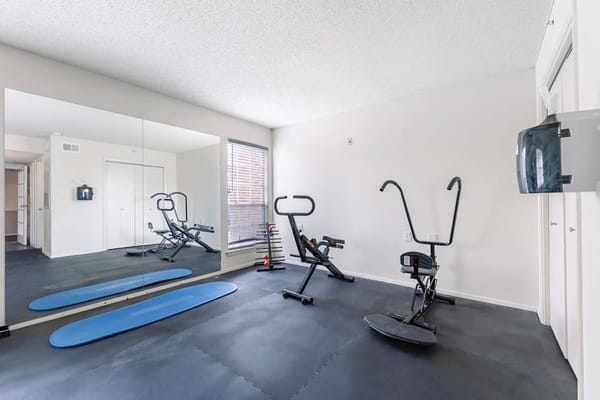 Fitness room with exercise equipment and mirrors