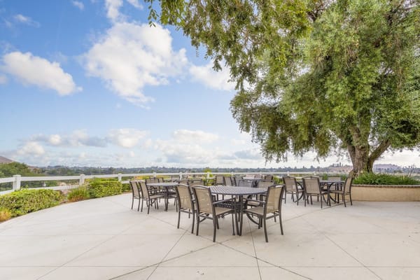 Patio area with tables and chairs overlooking a scenic view