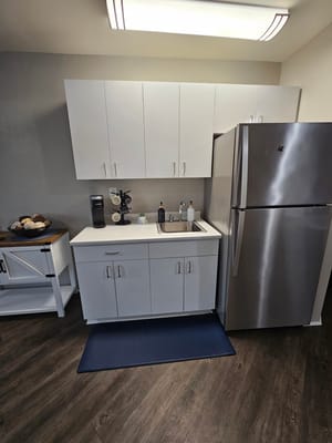 Compact kitchen with modern appliances and white cabinets