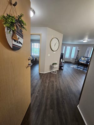 A view of the entryway into a welcoming living space with a clock and decorative elements.