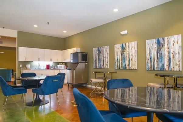 Interior of the community room with blue chairs and modern artwork