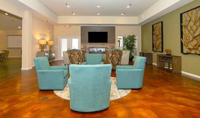 Living room with teal armchairs and a fireplace