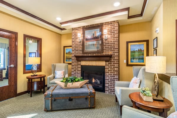 Lounge area featuring a fireplace, comfortable chairs, and decorative plants
