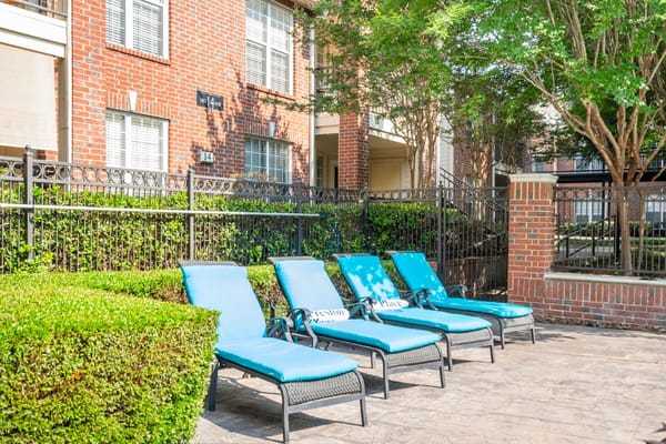 Four blue lounge chairs by a pool area at Preston Place