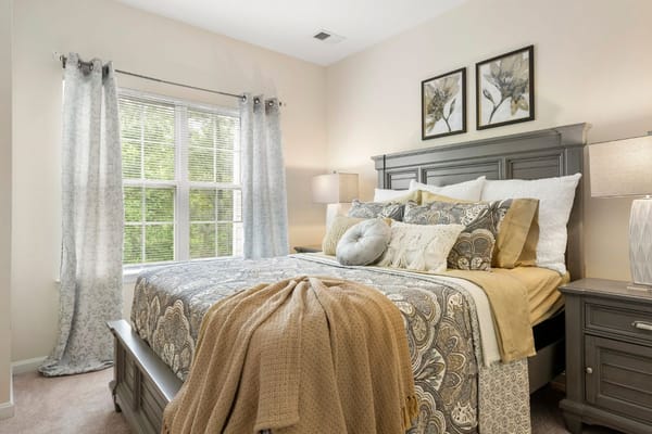Comfortable bedroom with a bed, decorative pillows, and large windows