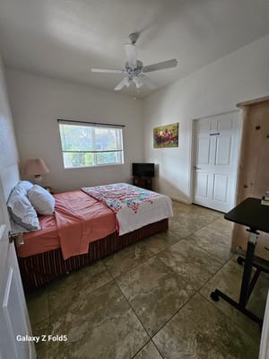 A bedroom featuring a bed with floral bedding and a small TV.