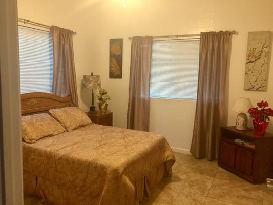 A well-decorated bedroom with a bed, lamp, and window curtains