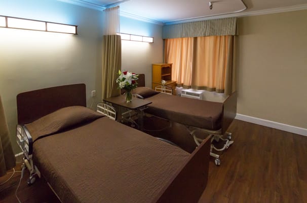 A cozy resident room with two beds and flowers