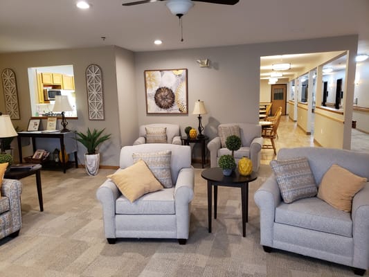Comfortable seating area with chairs and tables in Sienna Crest Assisted Living.