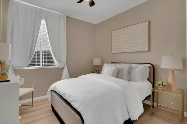 Stylish bedroom with white bed linens and natural light.