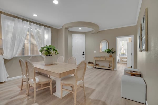 Brightly lit dining area with a wooden table and chairs