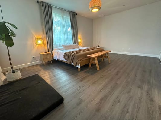 Cozy bedroom with a bed, bench, and plant in Safe Haven - Oakley.