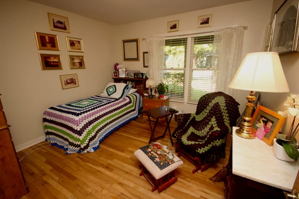 A well-decorated senior bedroom featuring a crocheted blanket and natural light.