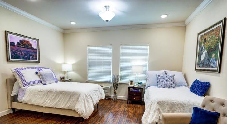 Cozy bedroom with two beds, window light, and artwork.