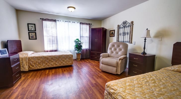 A cozy bedroom with two beds and a comfortable chair