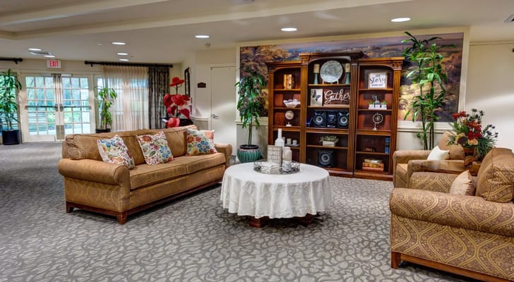 A cozy living room with comfortable couches, a coffee table, and decorative shelves.