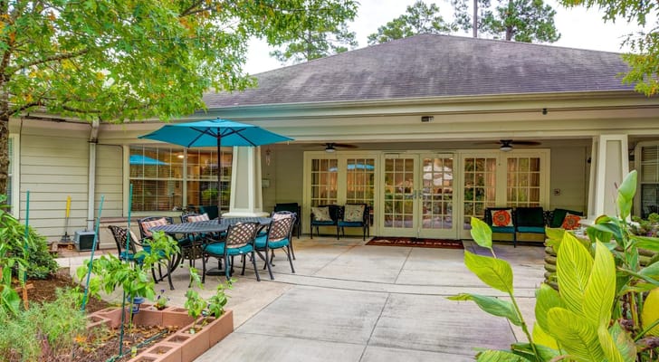 Outdoor patio with tables and umbrellas at The Auberge at The Woodlands
