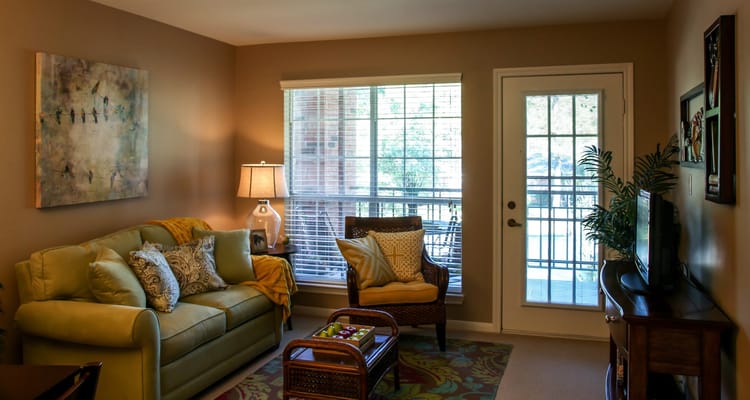 Bright and inviting living room with a green couch and a view of the outdoors.