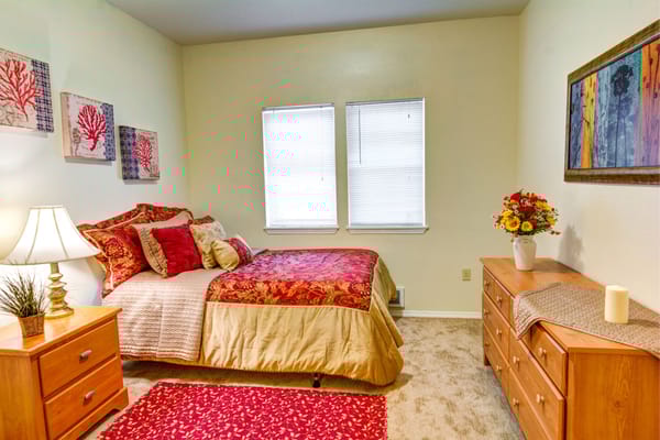 Well-decorated bedroom with a bed, nightstand, and dresser.