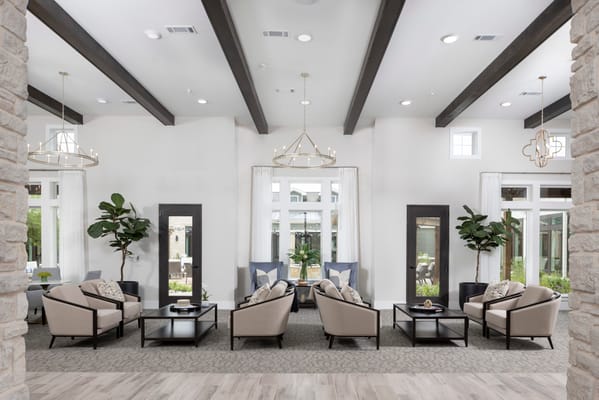 Modern and cozy lobby seating area with large windows and plants.