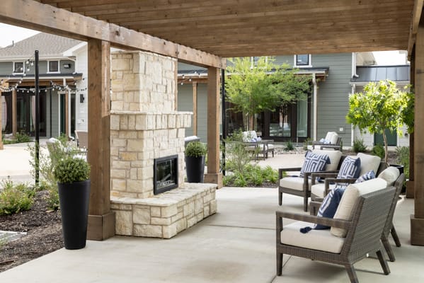 Outdoor seating area with a fireplace and greenery