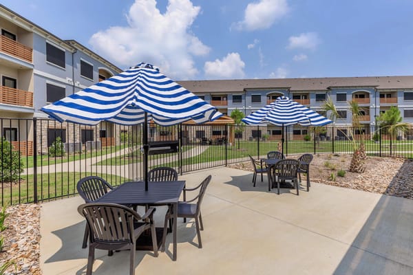 Outdoor seating area with striped umbrellas and tables